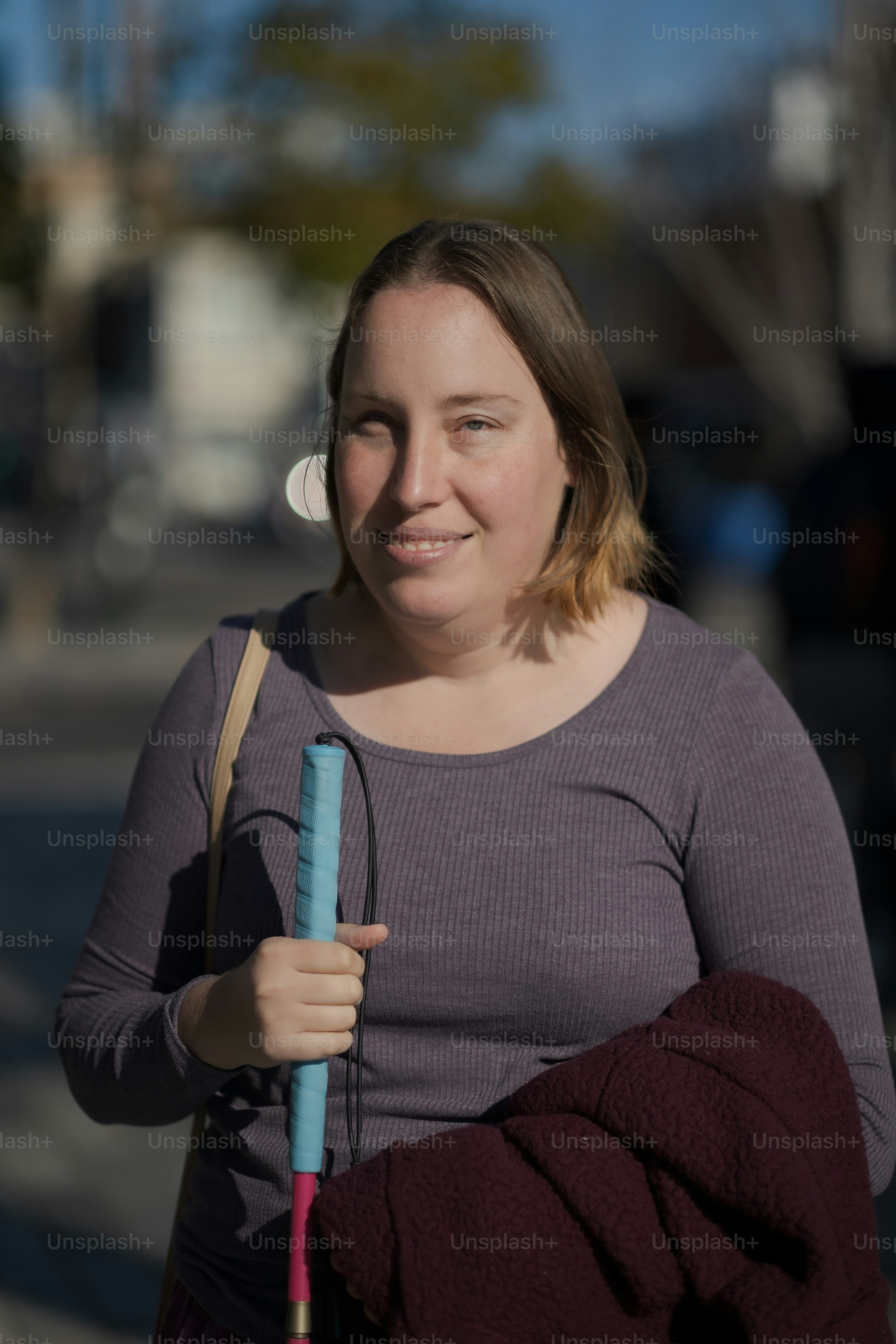 uma mulher que segura um guarda-chuva azul em uma rua da cidade