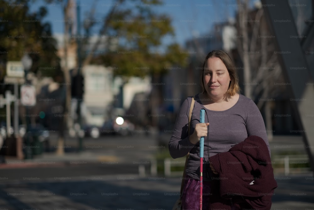 a woman walking down a street holding a blue umbrella