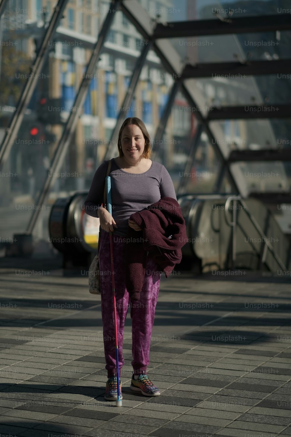a woman is walking with a purple umbrella