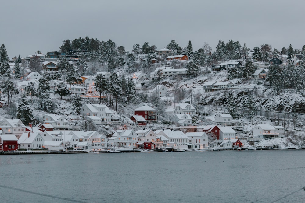 a snow covered town sits on the edge of a body of water