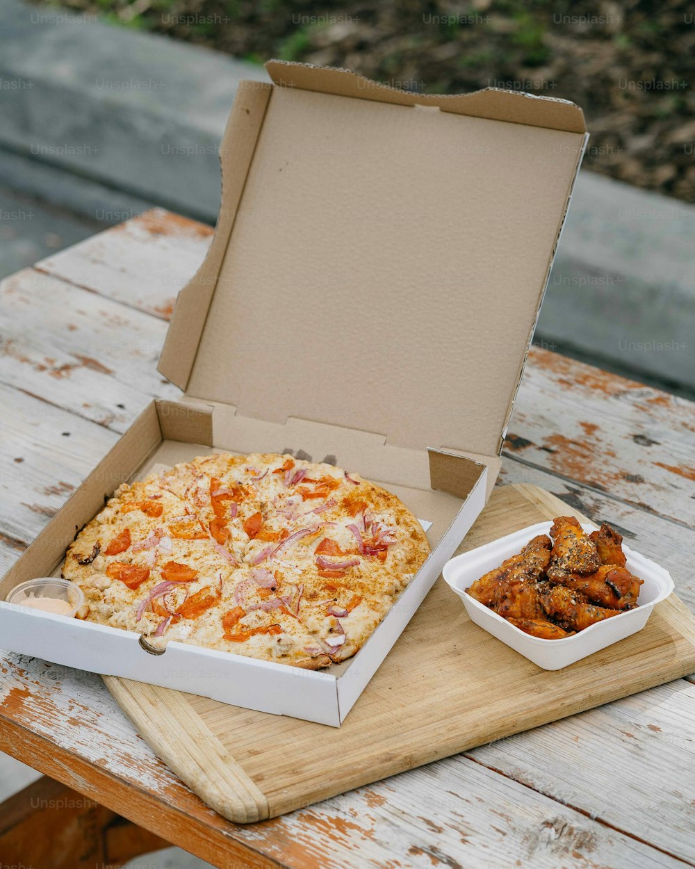 uma caixa de pizza sentada em cima de uma mesa de madeira