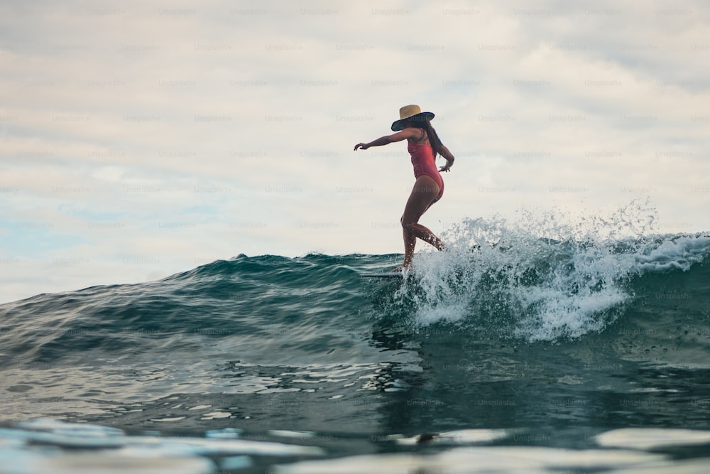 a woman riding a wave on top of a surfboard