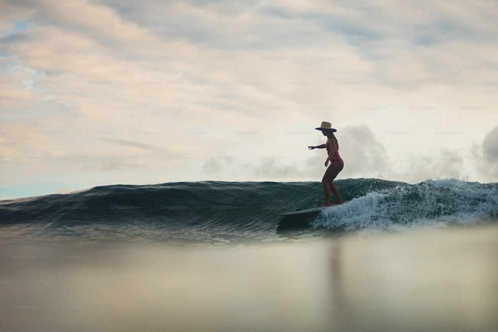Eine Frau, die auf einem Surfbrett auf einer Welle reitet