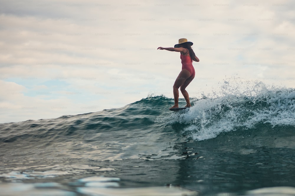 a woman riding a wave on top of a surfboard