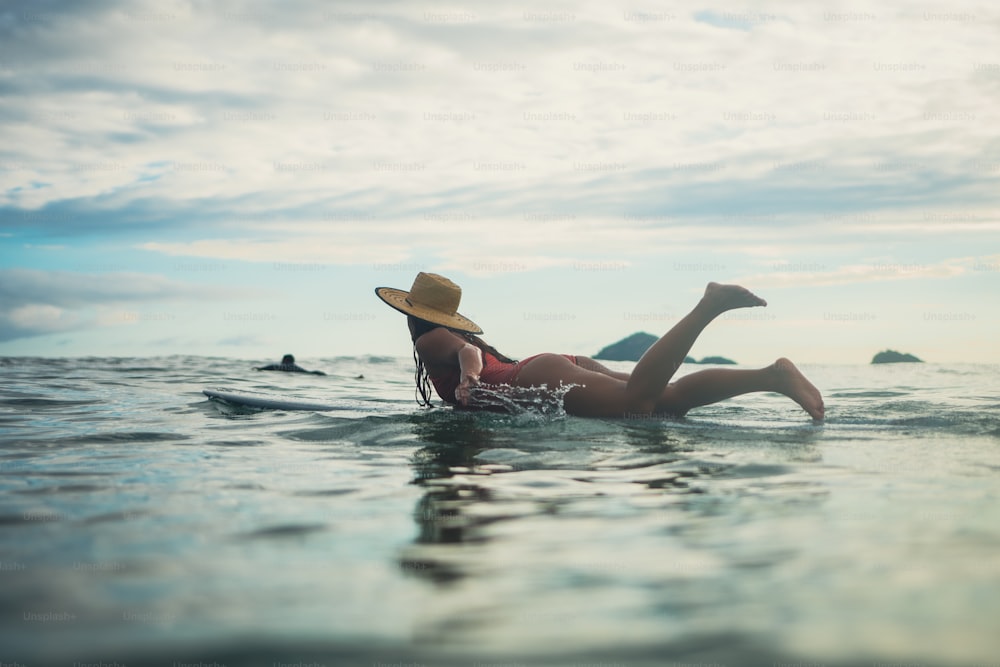 a woman laying on a surfboard in the ocean