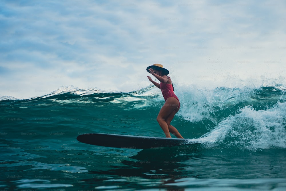 a woman riding a surfboard on top of a wave