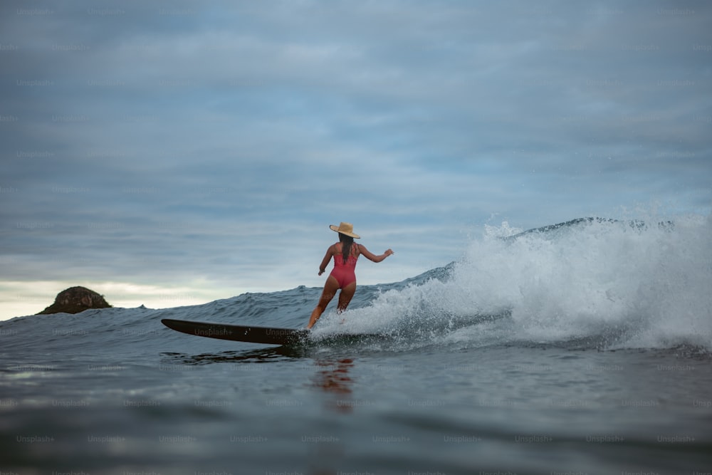 a woman riding a surfboard on a wave in the ocean