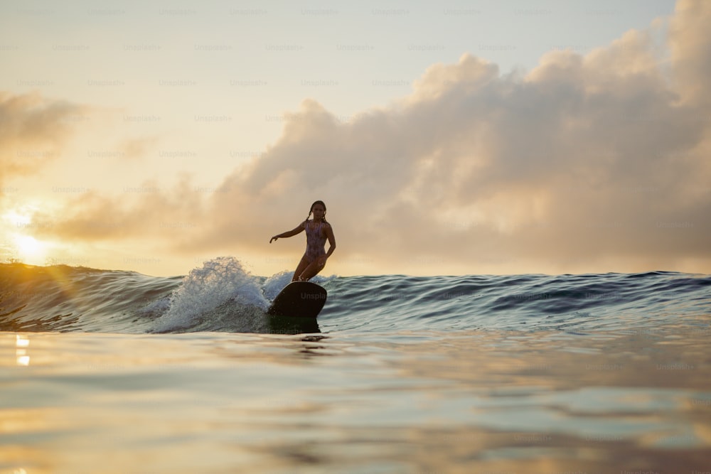 Una mujer montando una ola encima de una tabla de surf