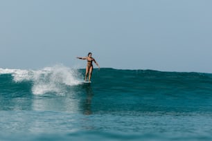uma mulher que monta uma onda em cima de uma prancha de surf