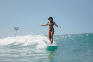 a woman riding a surfboard on a wave in the ocean