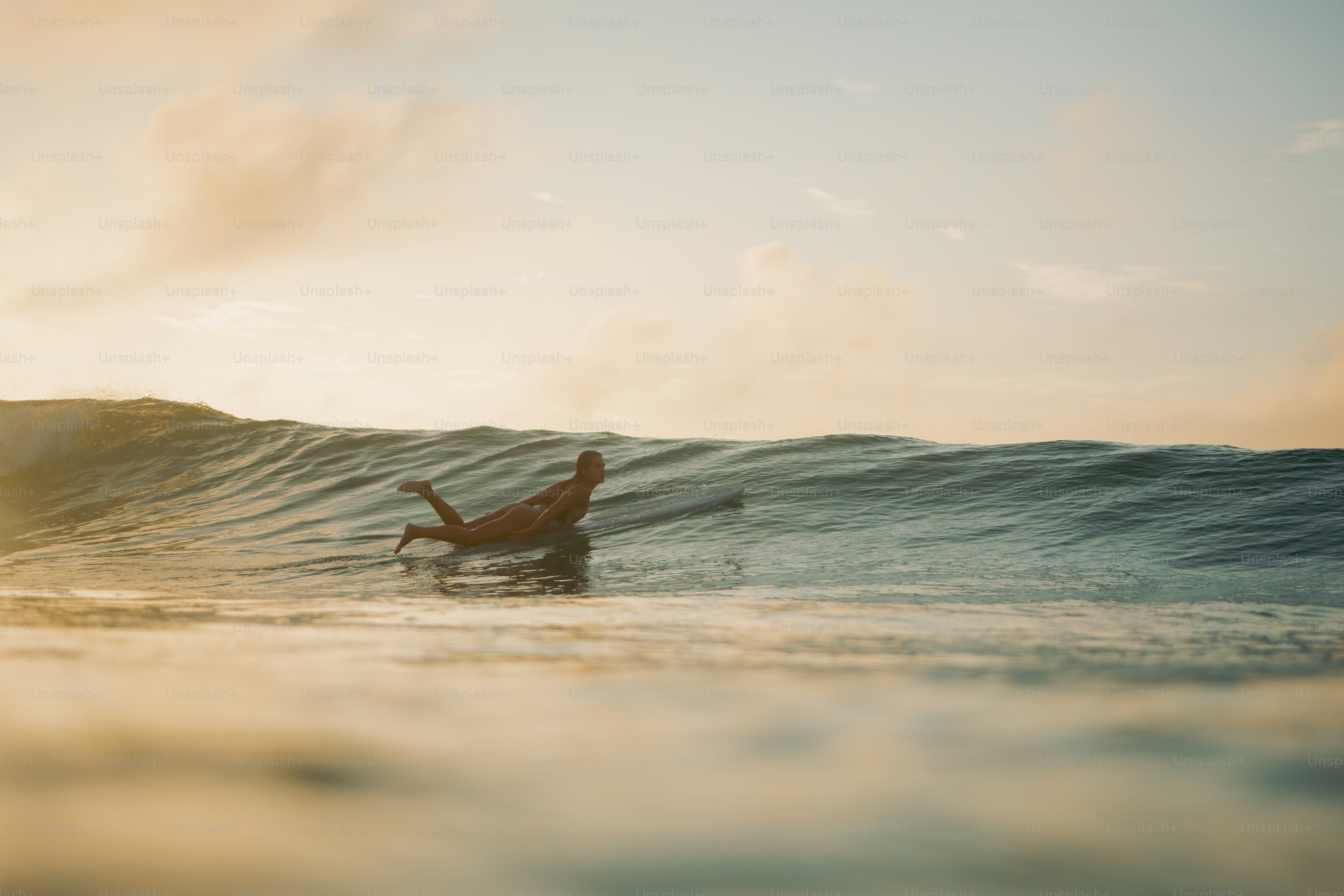 A woman riding a wave on top of a surfboard photo – Beach Image on Unsplash