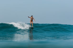 Eine Frau, die auf einem Surfbrett auf einer Welle reitet