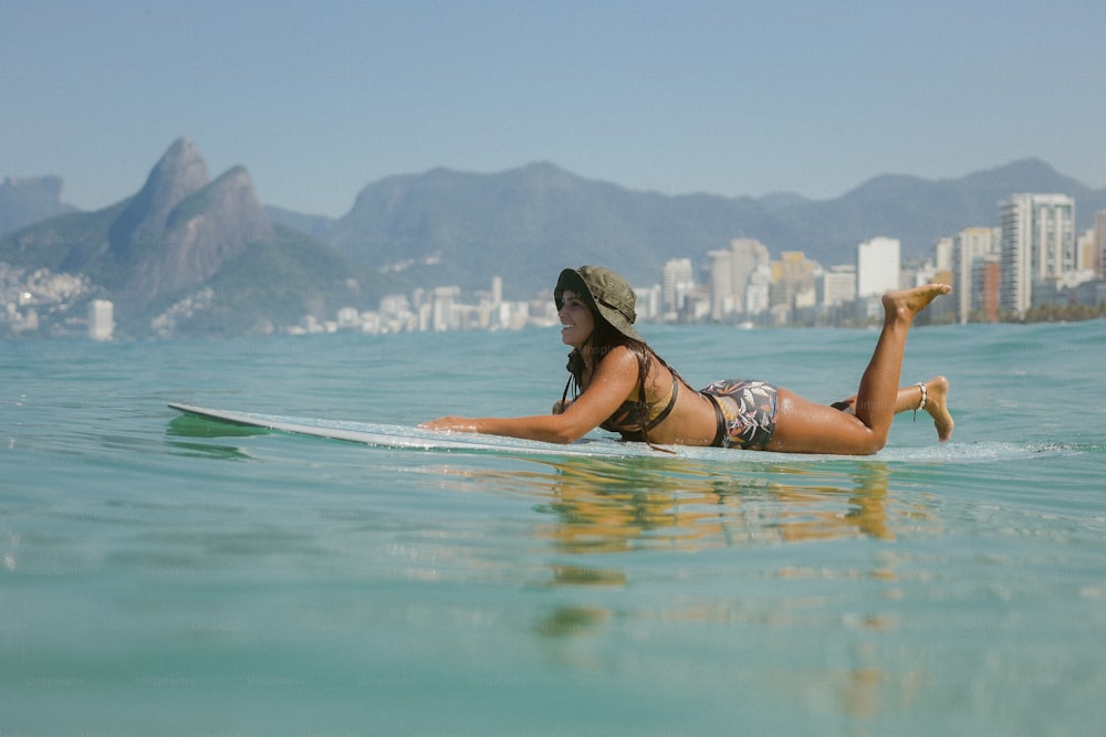 Eine Frau liegt auf einem Surfbrett im Meer