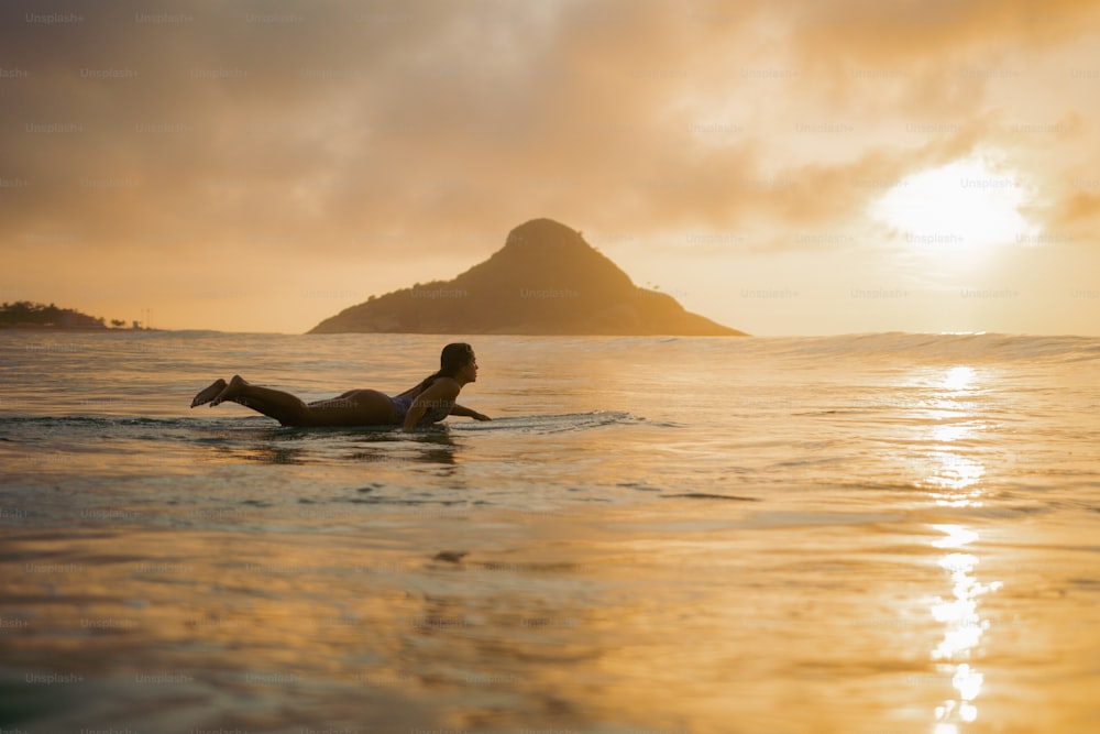 바다에서 서핑 보드에 누워있는 여자