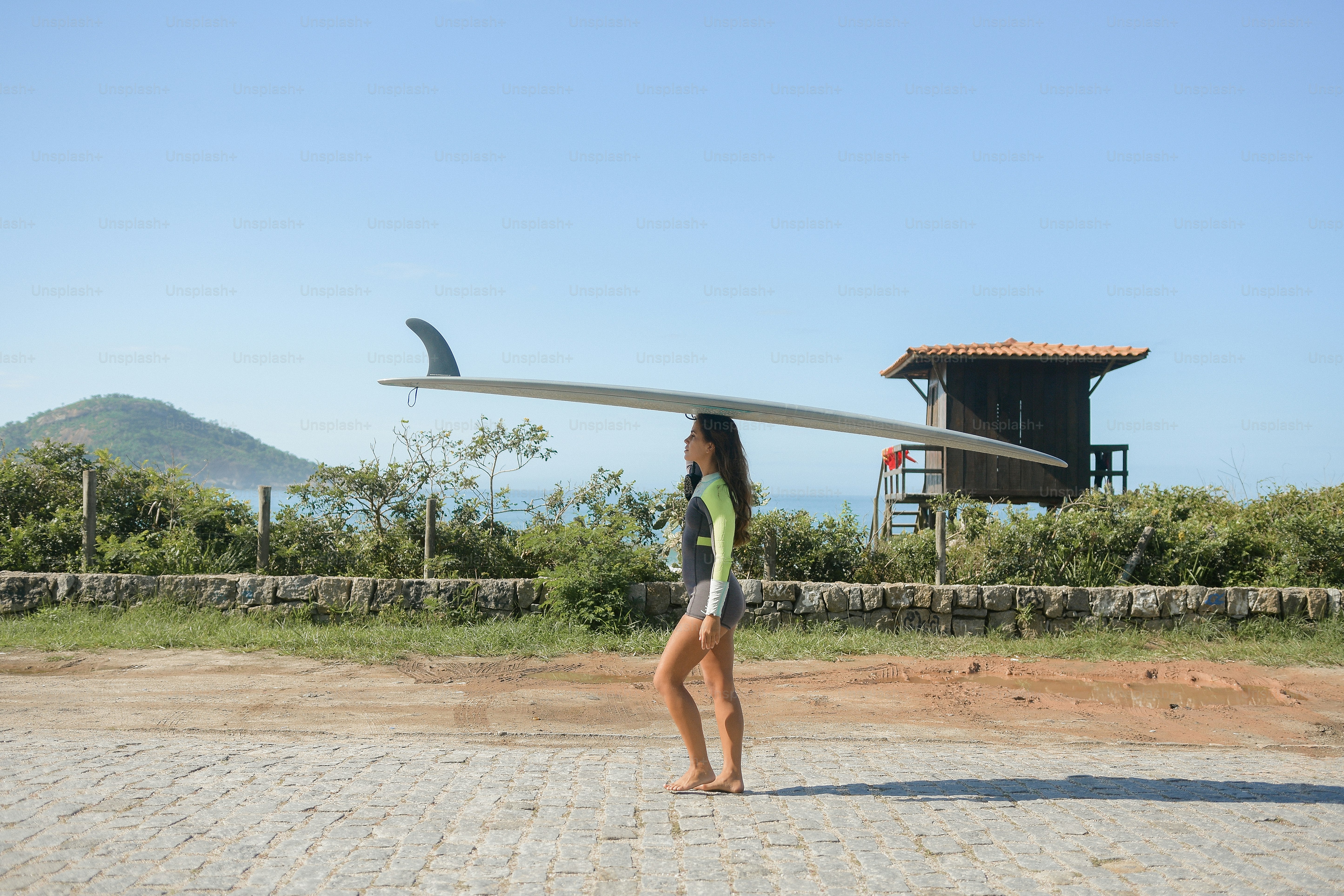 a woman holding a surfboard on top of her head
