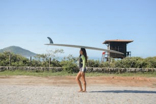 a woman holding a surfboard on top of her head