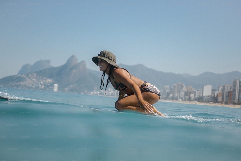 a woman kneeling on a surfboard in the ocean