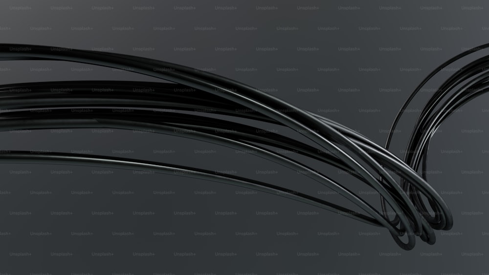 Un montón de cables negros sobre un fondo gris