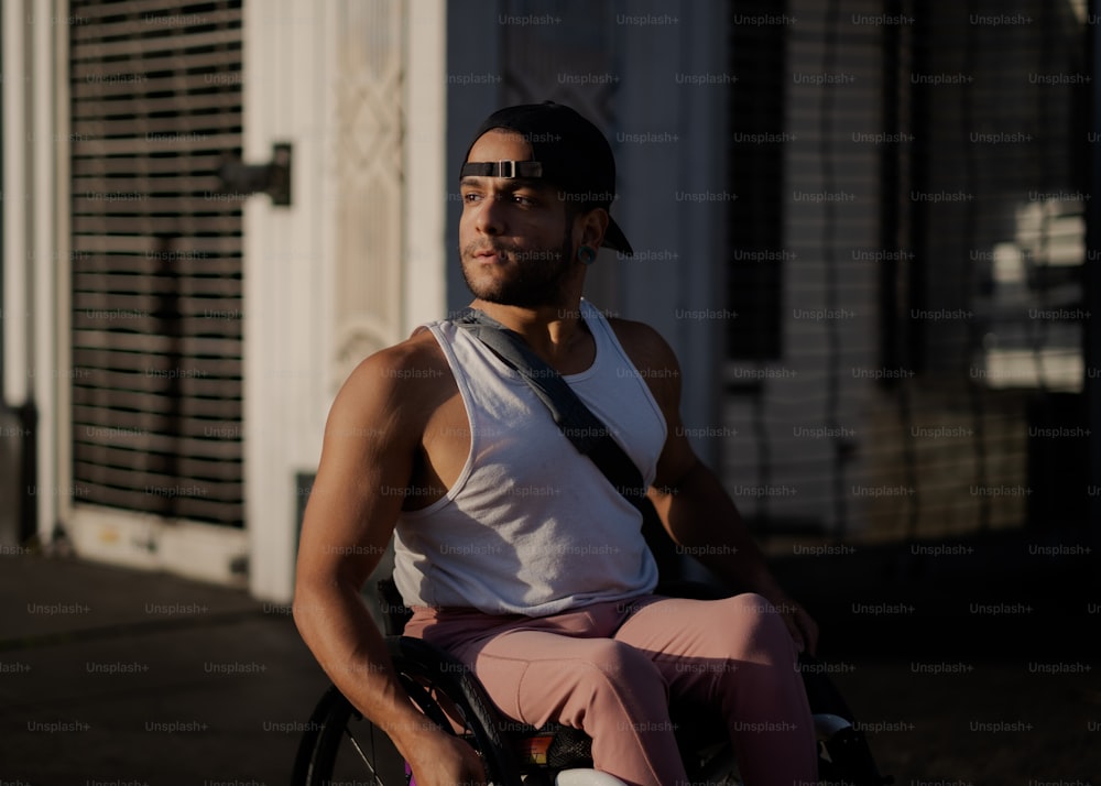 um homem sentado em uma cadeira de rodas na frente de um edifício