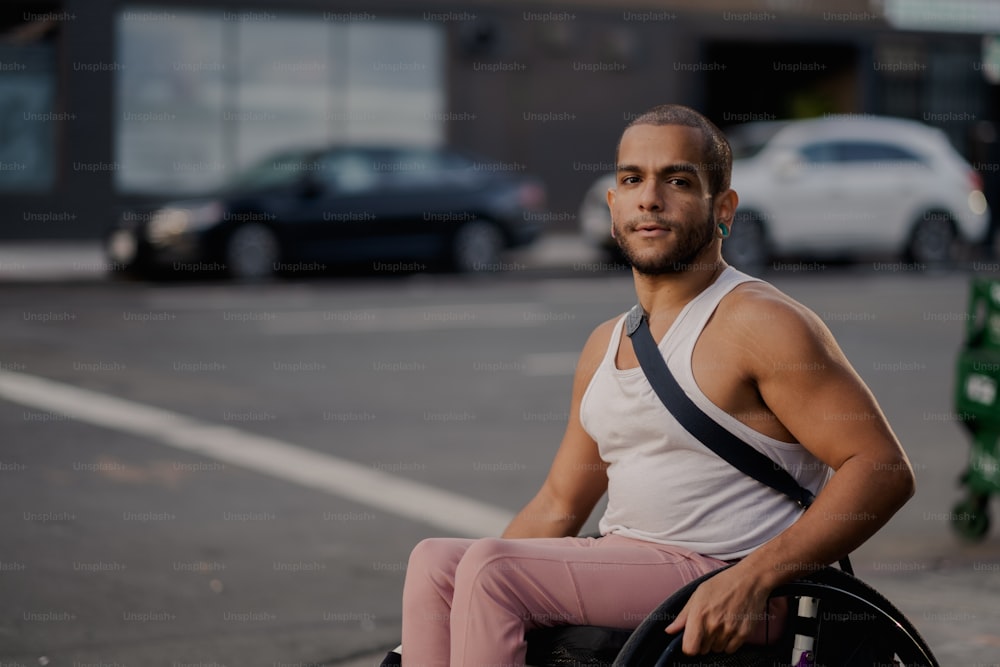 Un homme assis sur un fauteuil roulant sur le bord de la route