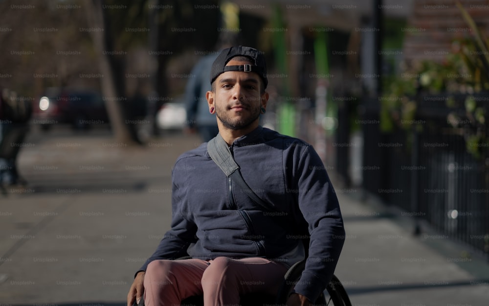 um homem sentado em uma cadeira de rodas em uma calçada