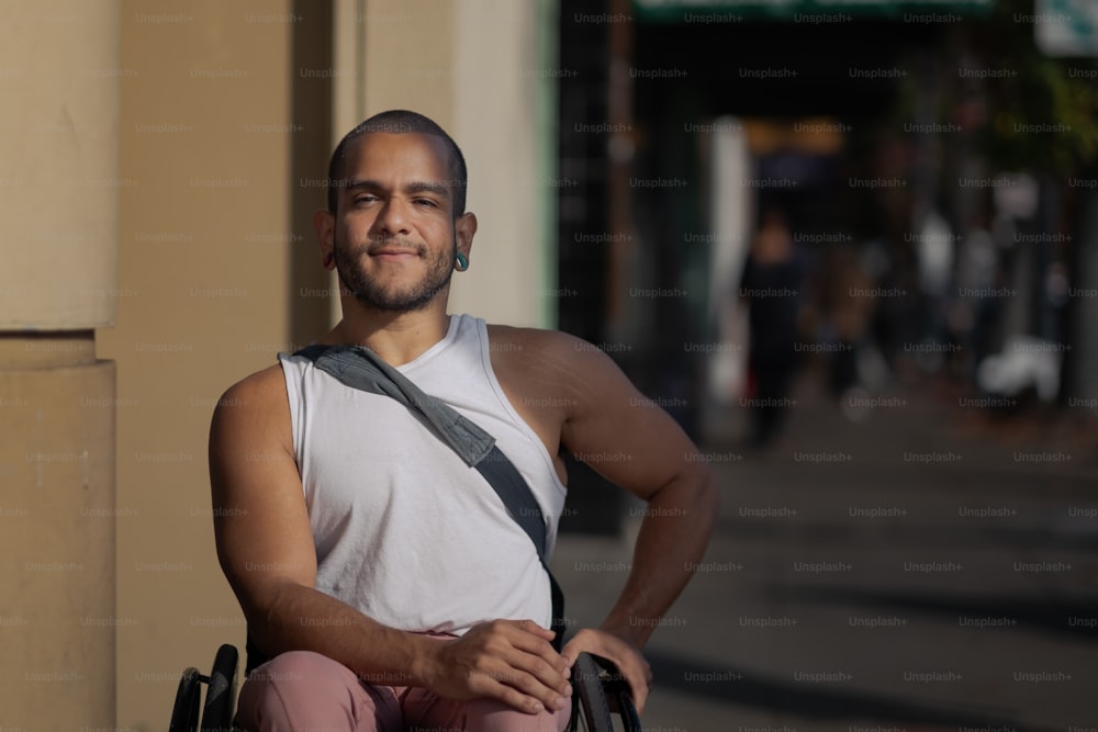Un homme assis dans un fauteuil roulant devant un immeuble