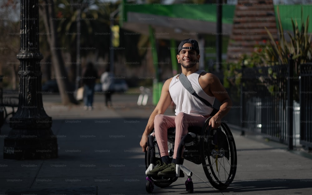 Un hombre sentado en una silla de ruedas en una acera