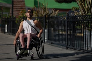um homem em uma cadeira de rodas em uma calçada