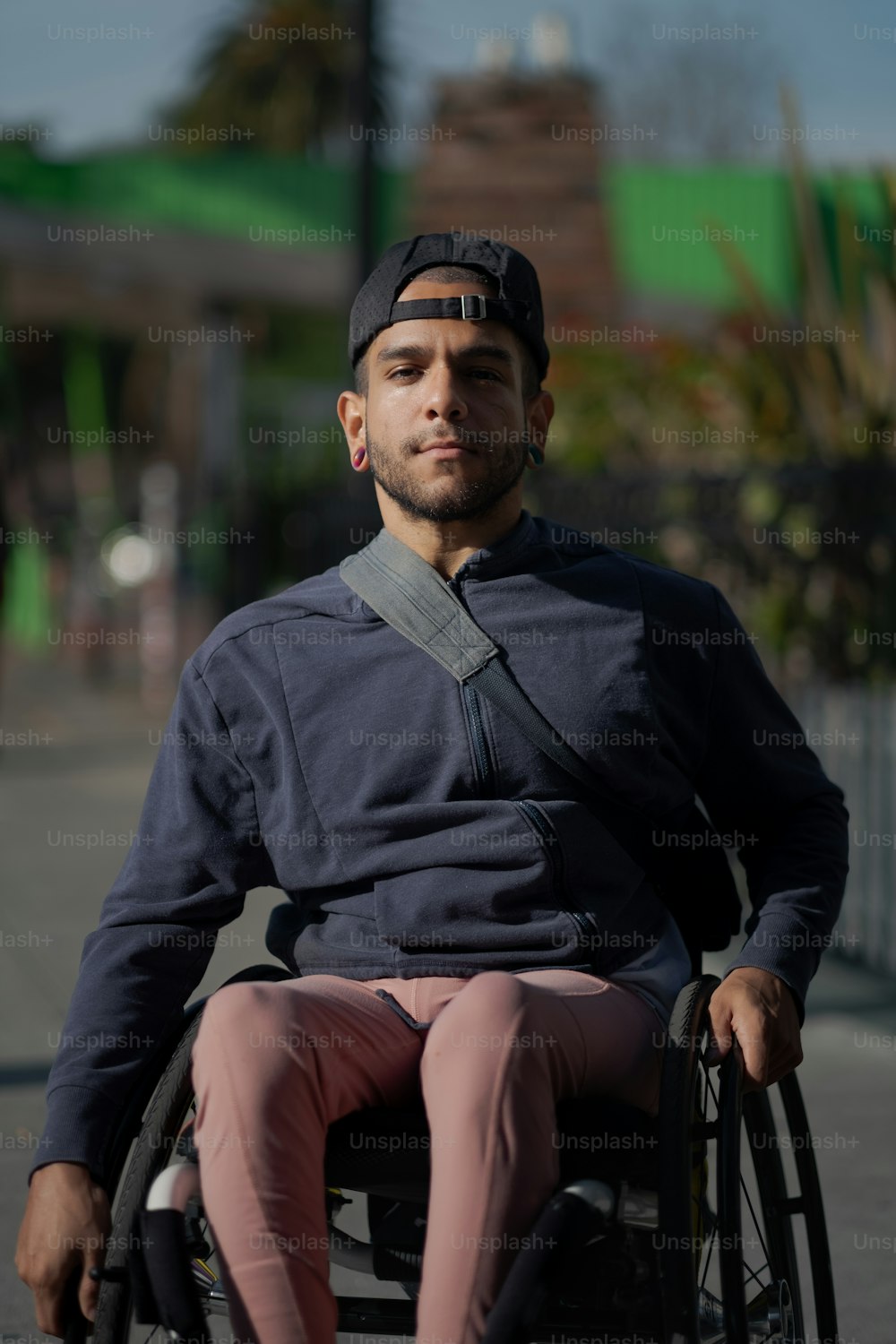 a man sitting in a wheel chair on a sidewalk