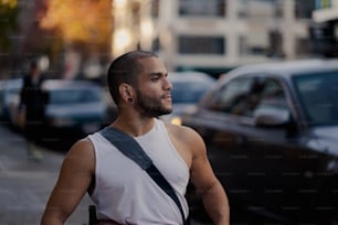 a man standing on the side of a street next to a car