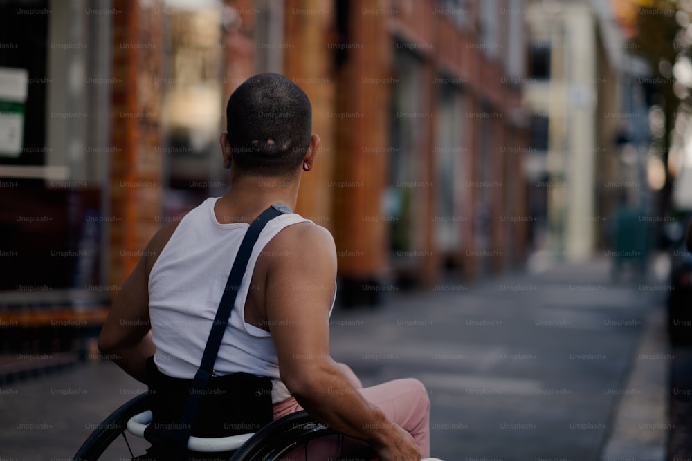 um homem em uma cadeira de rodas em uma rua da cidade