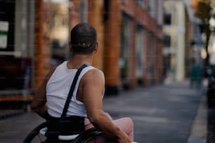 Un uomo su una sedia a rotelle su una strada della città
