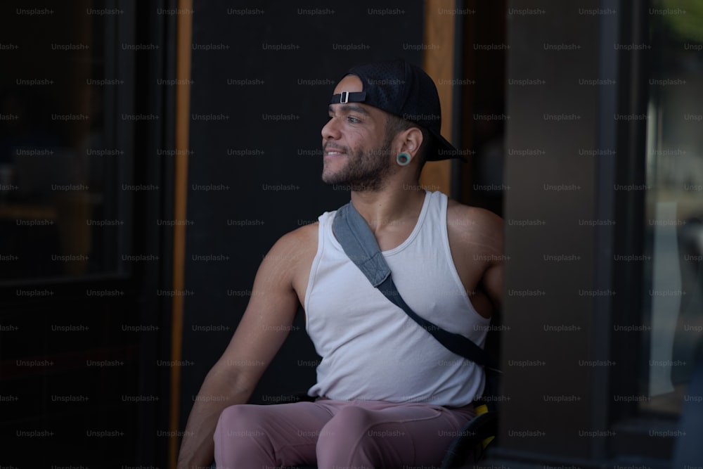 a man in a white tank top and pink pants