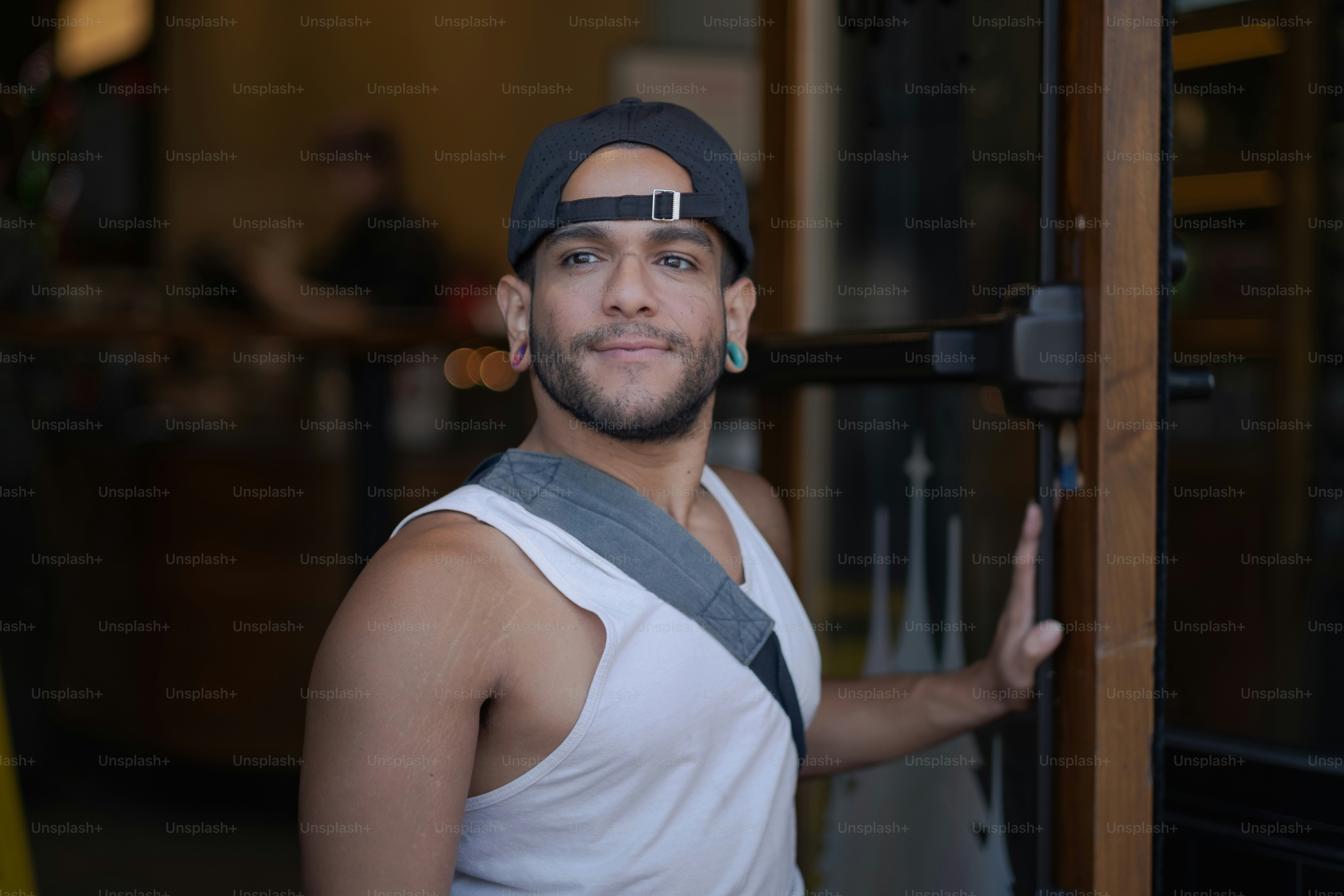 Ein Mann mit Hut und Hosenträgern steht vor einer Tür