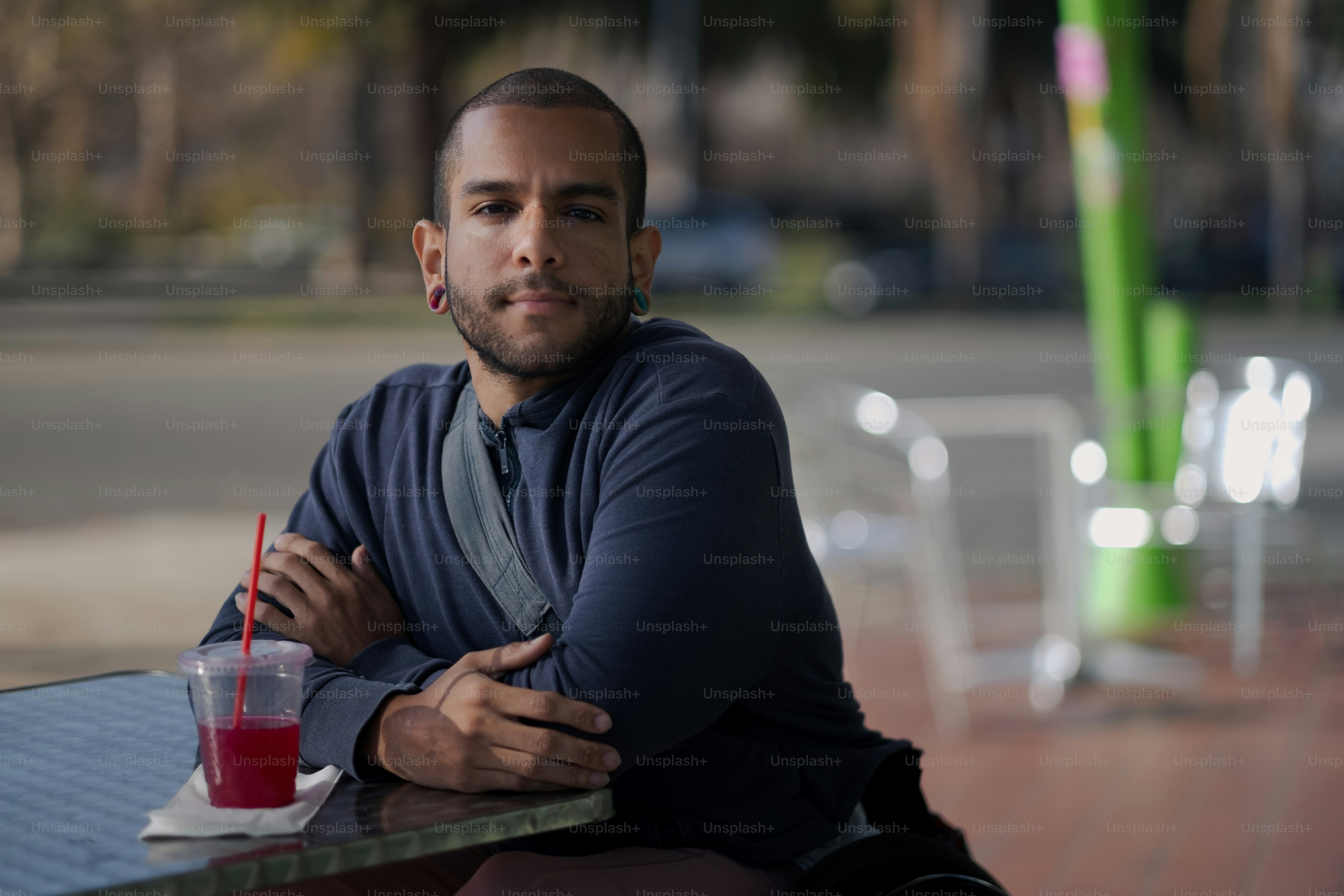 Un hombre sentado en una mesa con una bebida