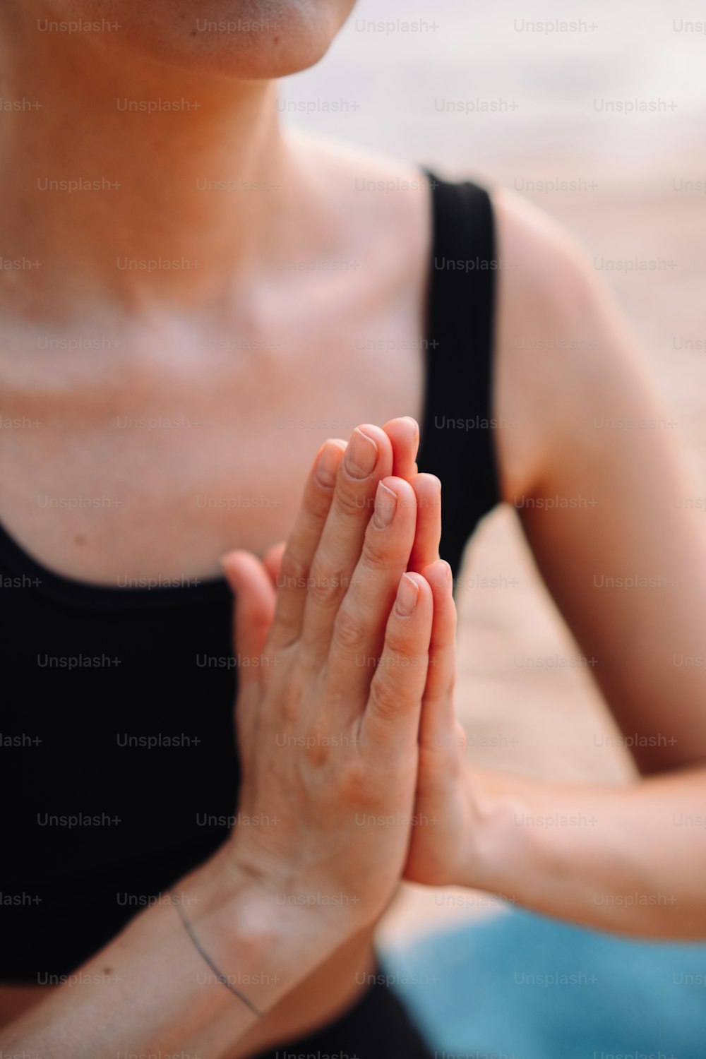 Una mujer sentada en posición de loto con las manos juntas