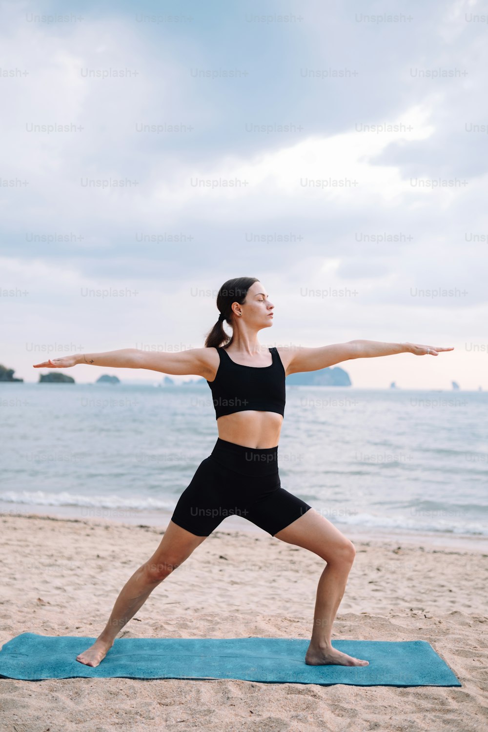 Una donna sta facendo yoga sulla spiaggia