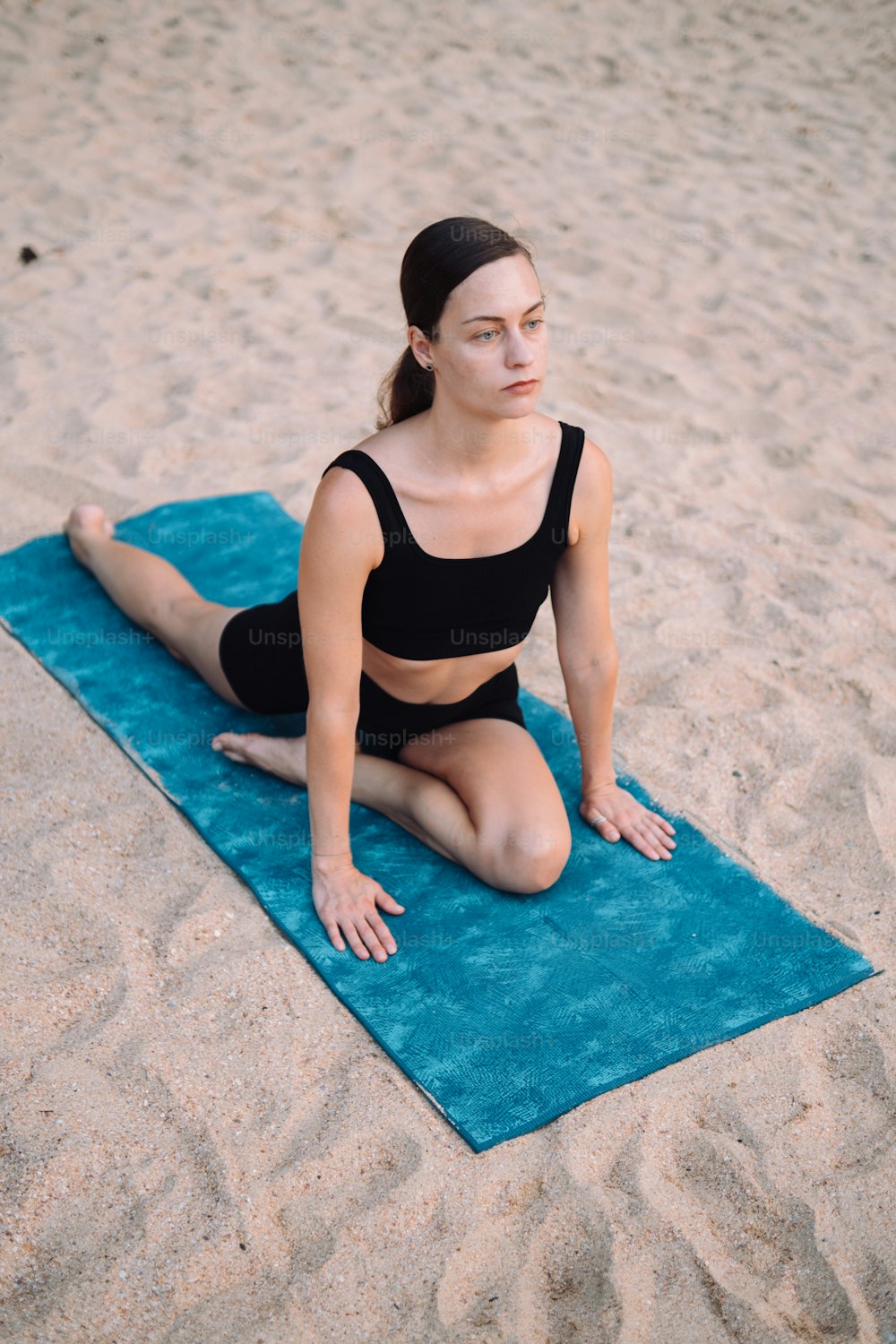 a woman sitting on a towel on the beach