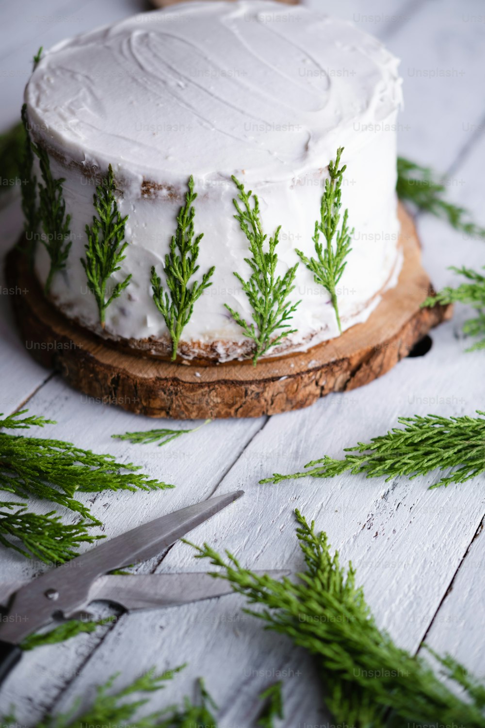 Un pastel con glaseado blanco y ramitas verdes