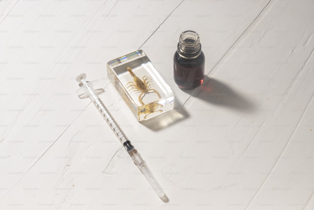 a bottle of liquid next to a syringe and a syringe