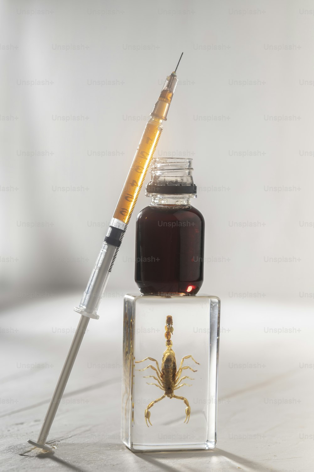 a bottle of liquid and a syringe sitting on top of each other