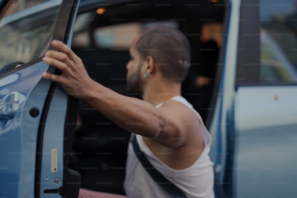 a man with his arm out of a car door