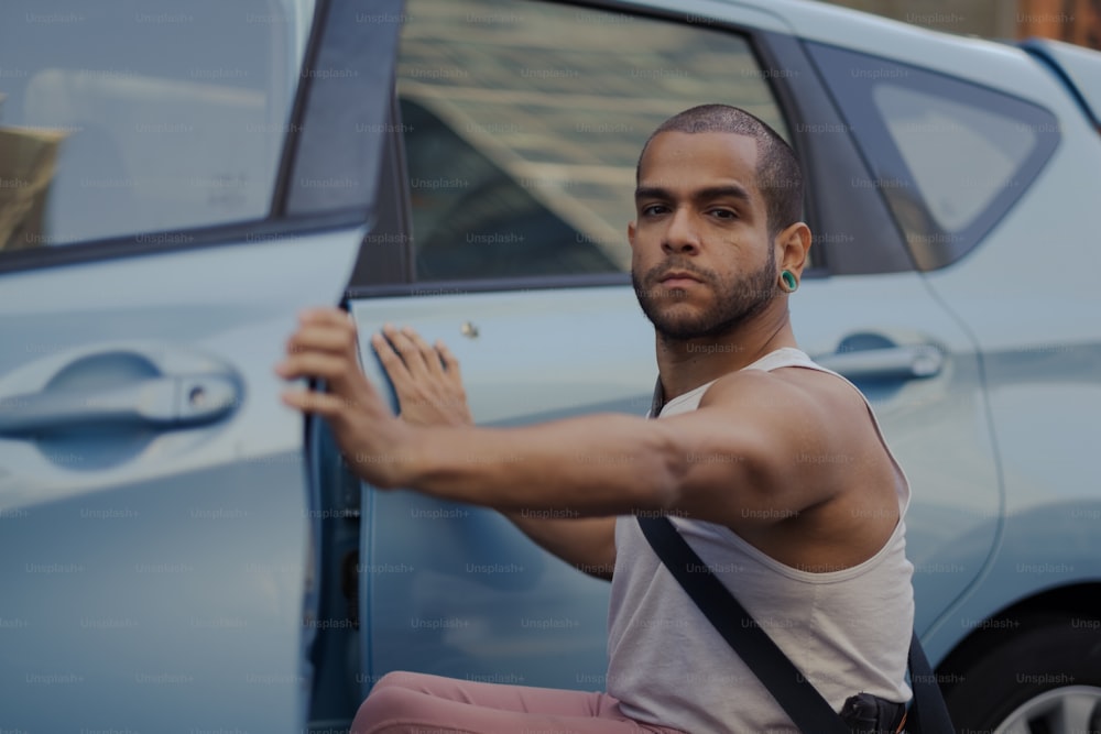 a man holding a cigarette in front of a car