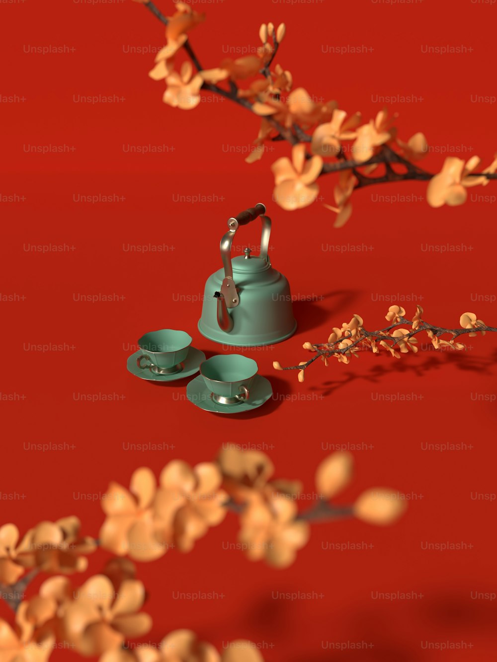 a tea kettle and two cups on a red surface