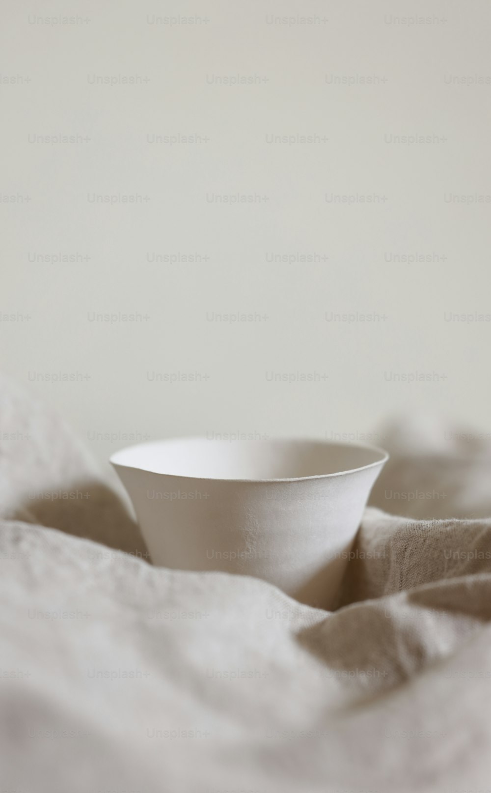 a white bowl sitting on top of a bed