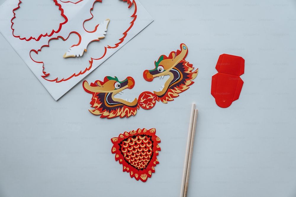 a table topped with paper cut outs and a pair of chopsticks