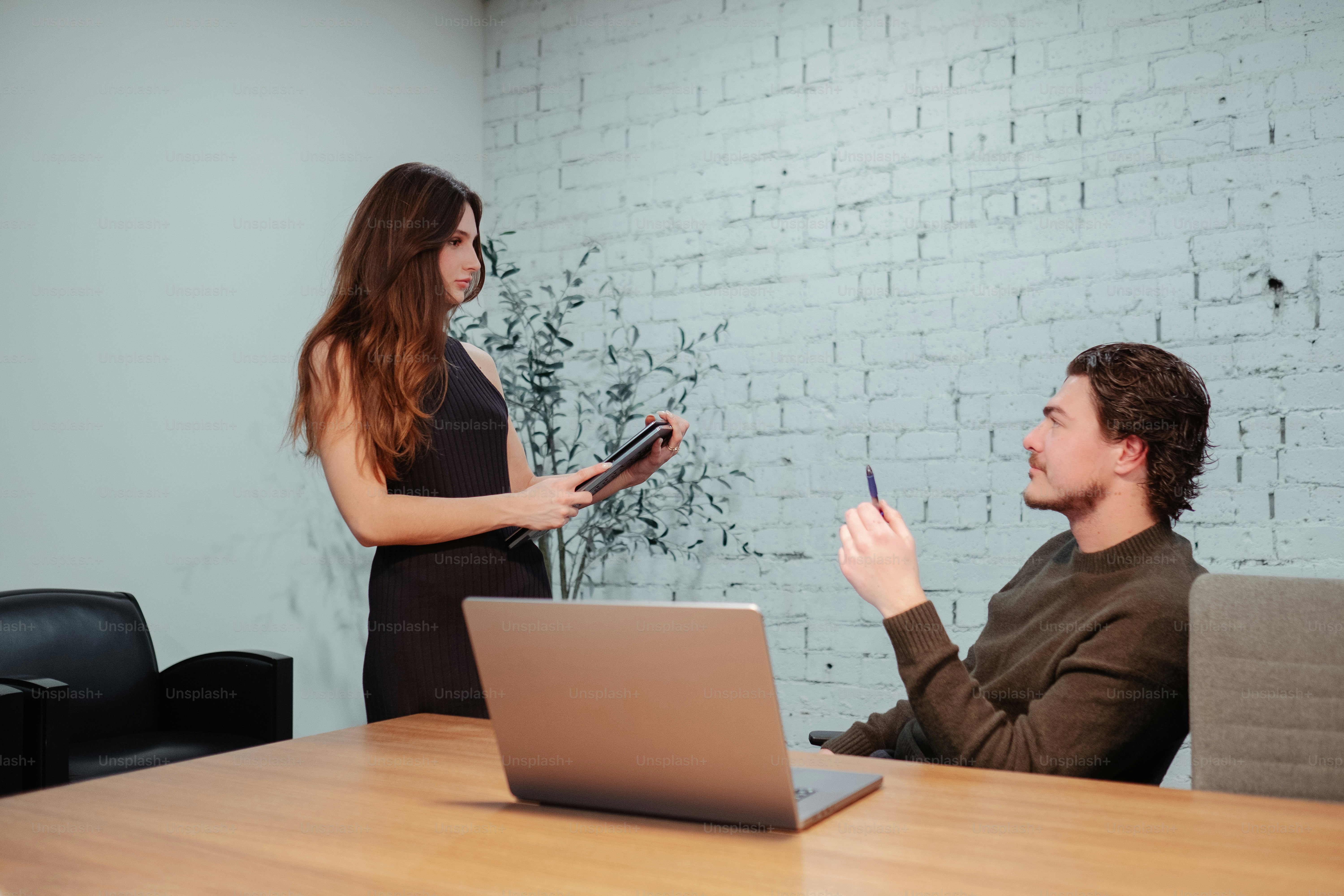 a woman standing next to a man in an office