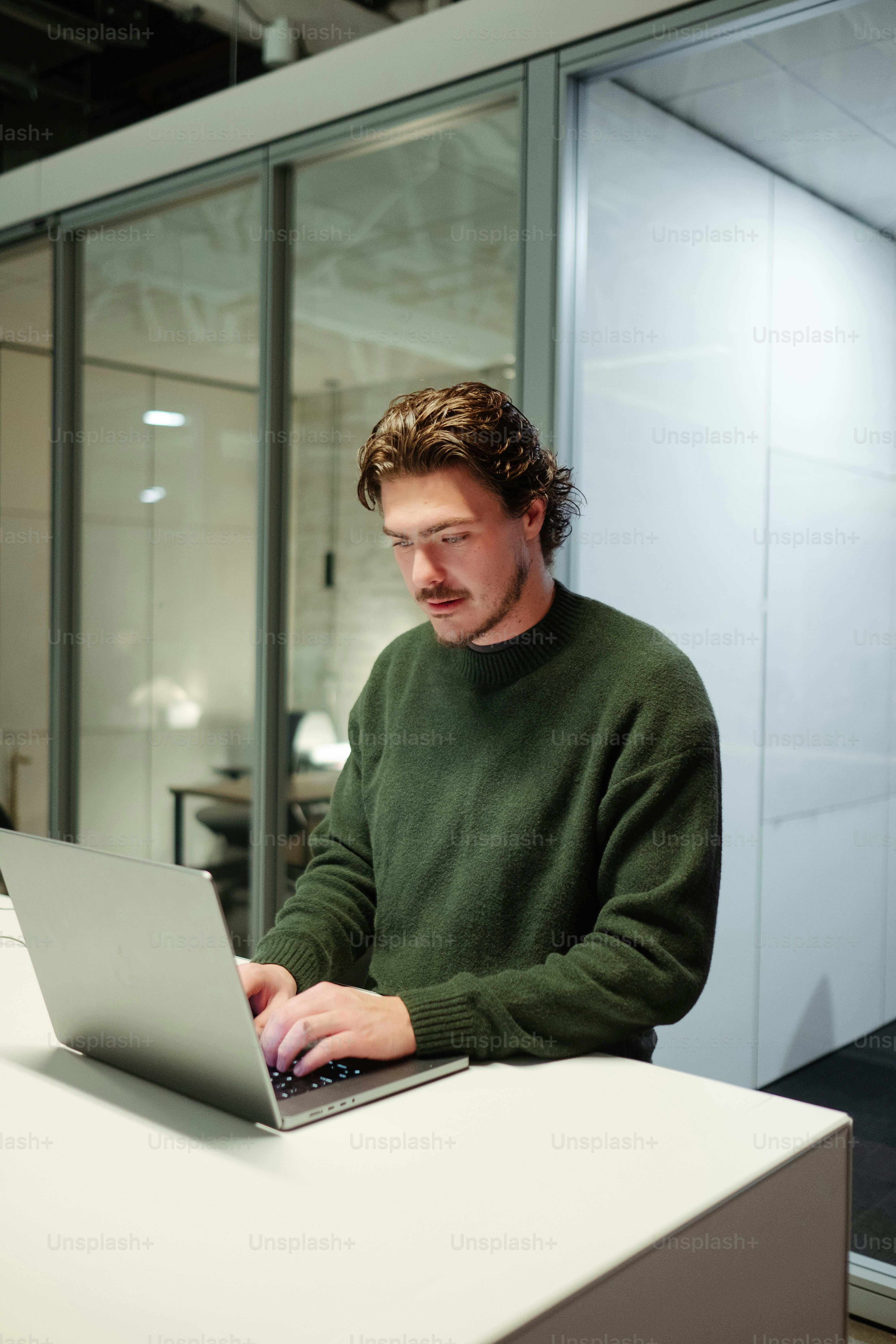 a man sitting at a table using a laptop computer