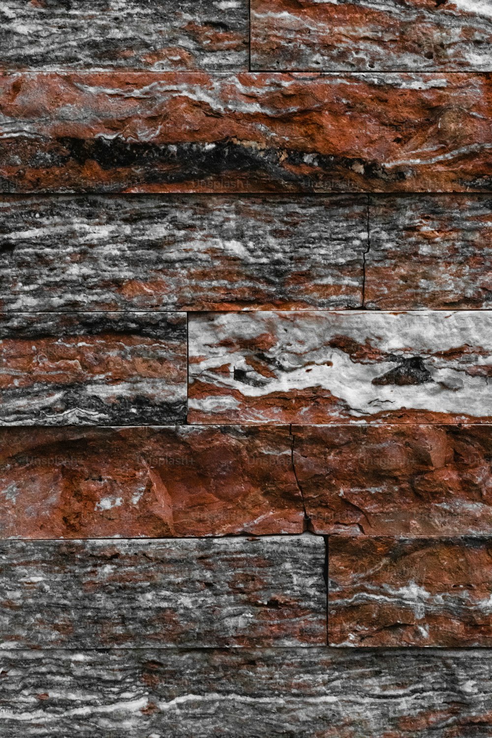 a close up of a red and black stone wall