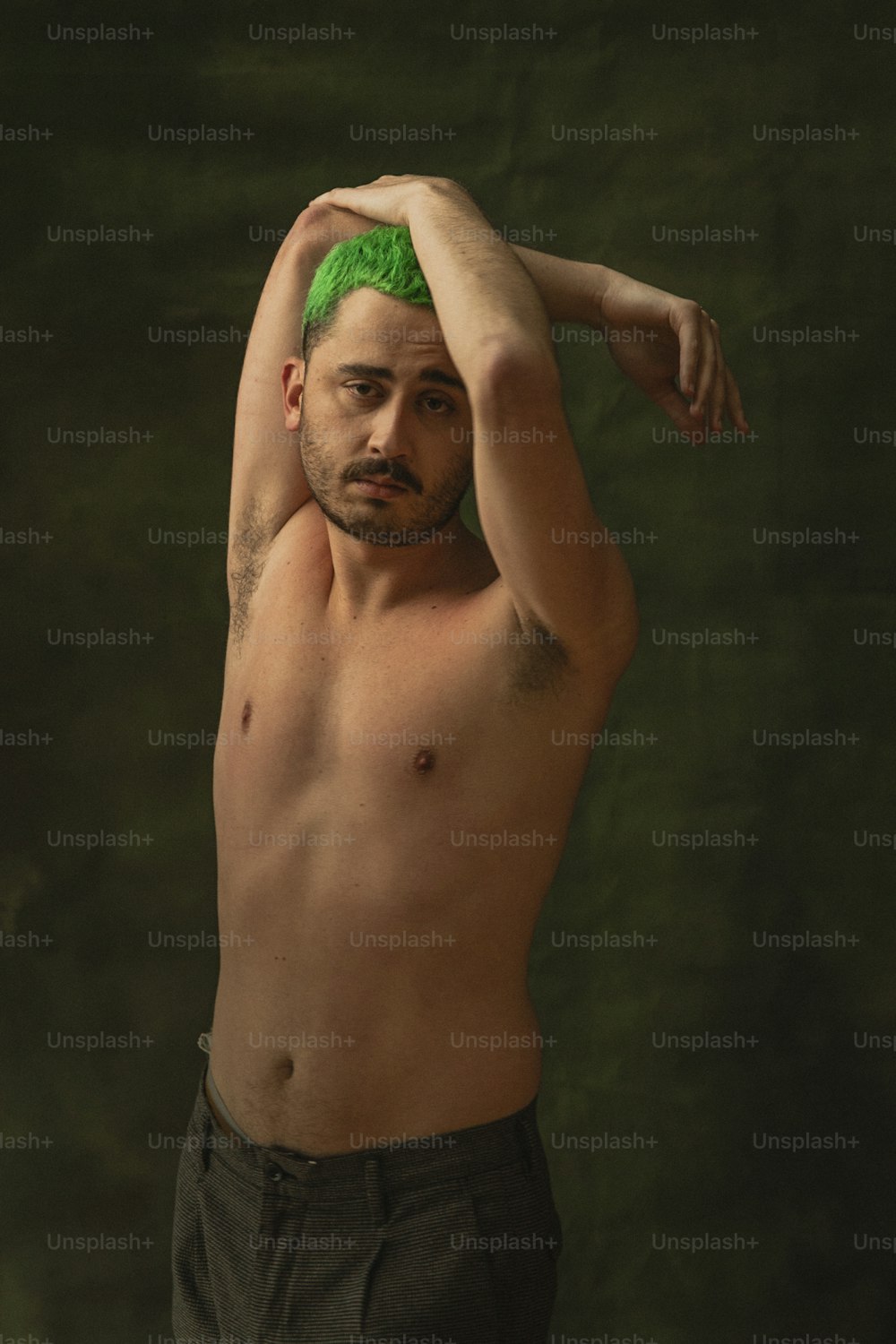 a shirtless man with a green mohawk